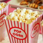 Close-up of gourmet popcorn in classic red and white striped boxes, perfect cinema snack.